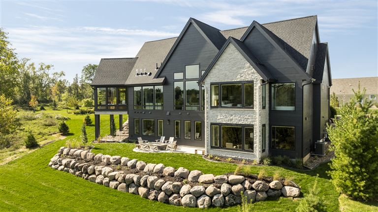 Upscale suburban bungalow with a green lawn and wooden architecture.