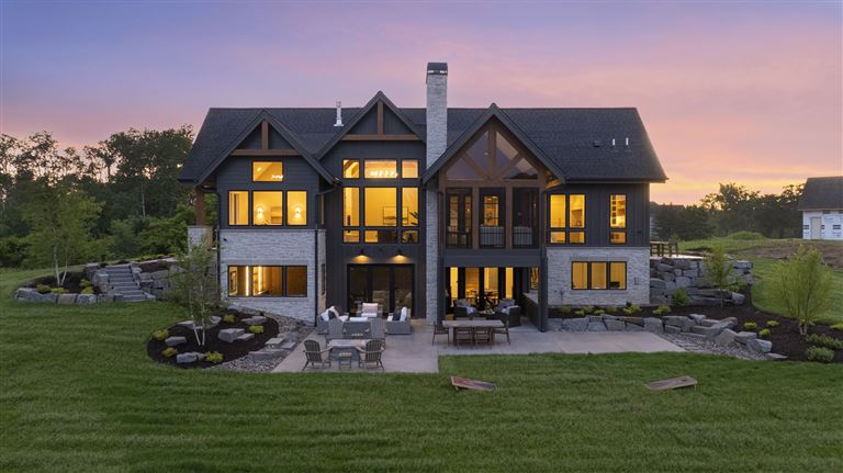 Aerial view of a suburban bungalow at twilight with a spacious yard.