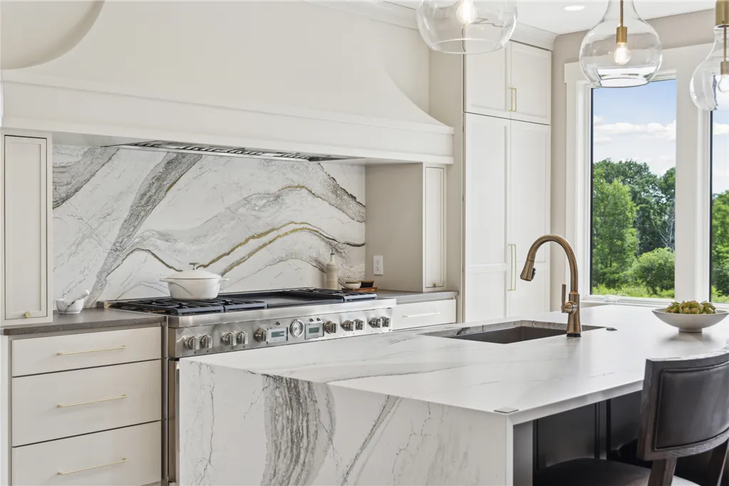 Luxury contemporary kitchen interior with stainless steel appliances and modern furniture.