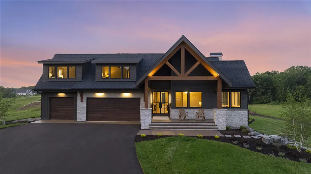 A twilight aerial view of a suburban bungalow with a driveway and roof in a residential area.