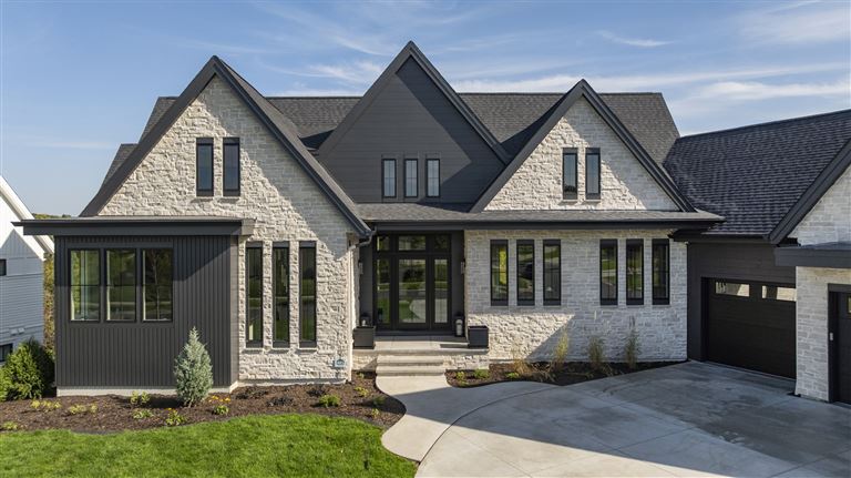 Elegant suburban home with a spacious driveway and upscale architecture.