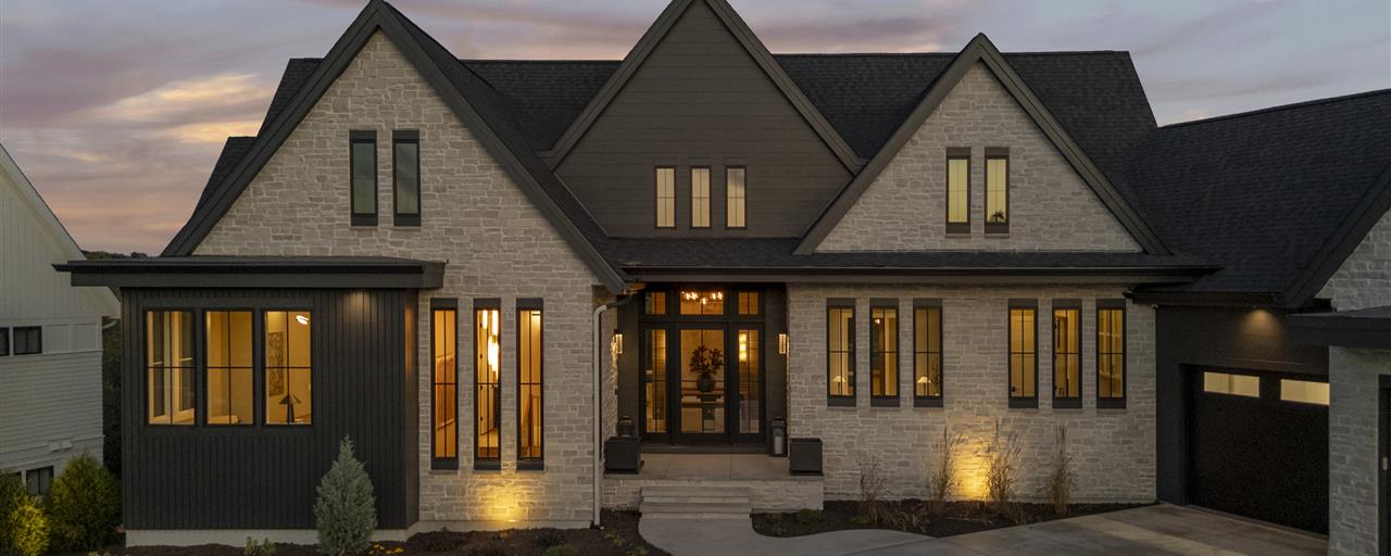 Bungalow surrounded by trees and grass in a summer landscape.