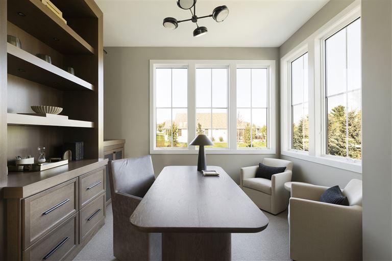 Contemporary minimalist dining room with modern furniture and large windows.