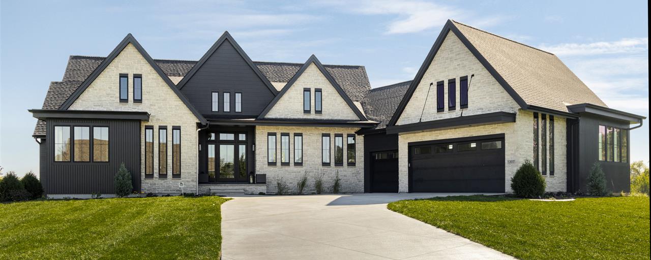Upscale suburban home with a driveway and lawn.