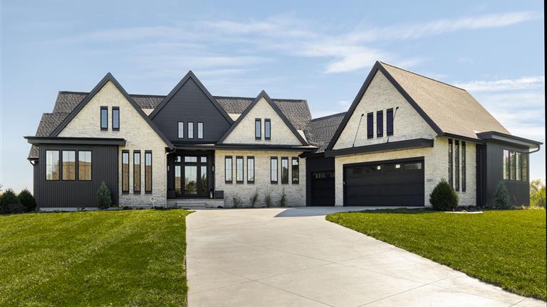 Upscale suburban home with a driveway and lawn.