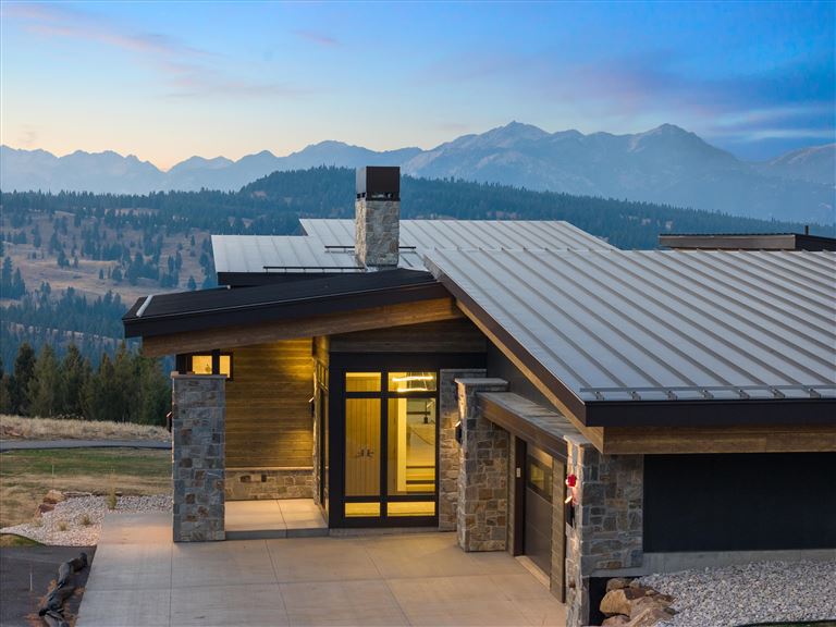 Wooden chalet in a mountain landscape with a clear sky.