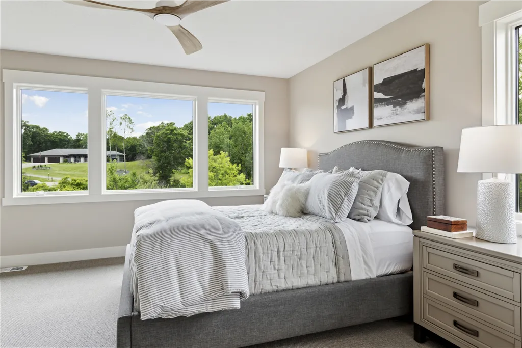 Contemporary bedroom with a bed, sofa, and large window.