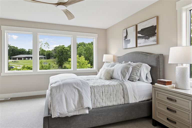 Contemporary bedroom with a bed, sofa, and large window.