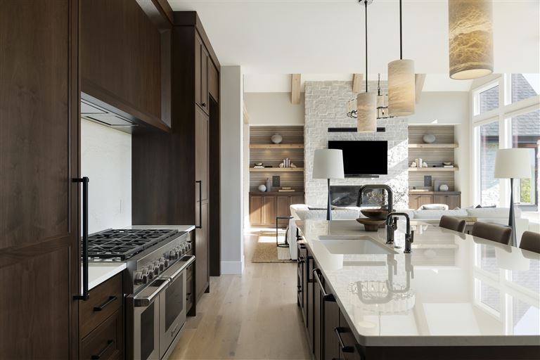 Contemporary minimalist kitchen with wooden cabinets and stainless steel appliances.