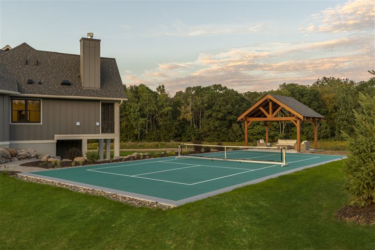 Twilight view of a suburban bungalow with a lawn and driveway.