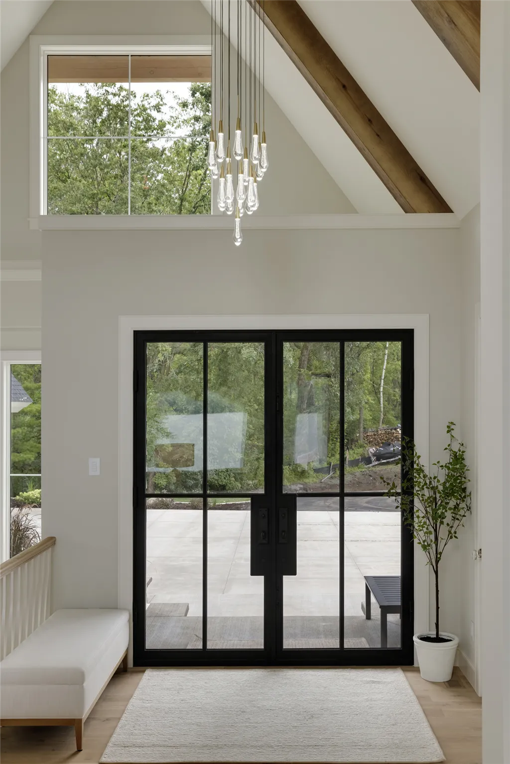 Luxurious contemporary home interior with large windows and wooden doorway by Hartman Homes.