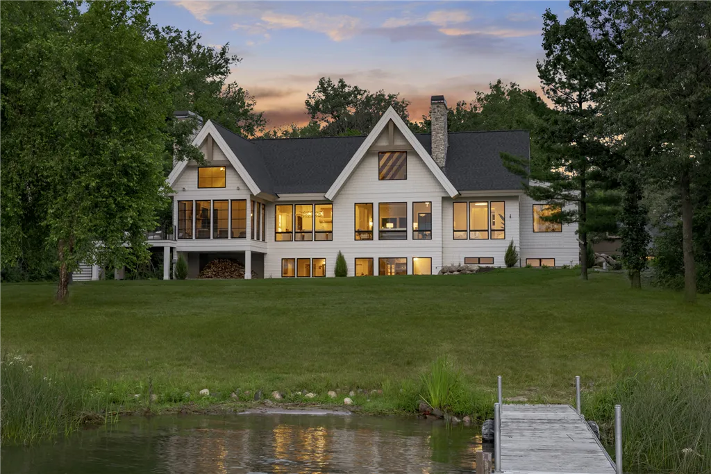 Luxury lakefront home in Stillwater, Minnesota with a spacious lawn and surrounding trees.