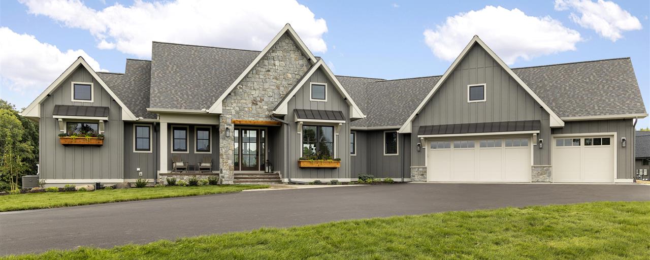 Luxury suburban home with a spacious driveway and well-maintained lawn.