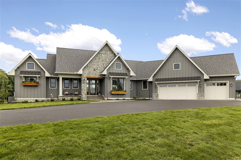 Luxury suburban home with expansive lawn and upscale architecture.