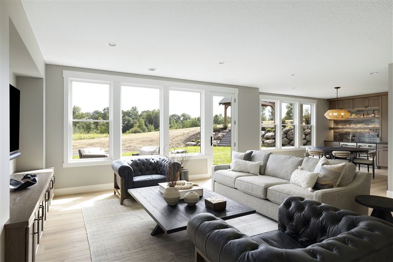 Contemporary living room with sofa, chairs, and coffee table in a luxury apartment.