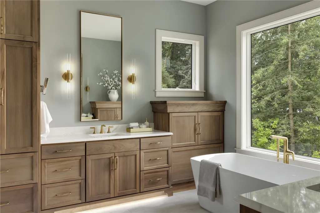 Contemporary luxury bathroom with bathtub, faucet, and wooden cabinetry by Hartman Homes.