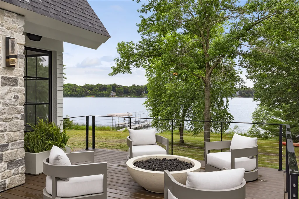 Luxury outdoor patio with contemporary seating on a wooden deck surrounded by nature.