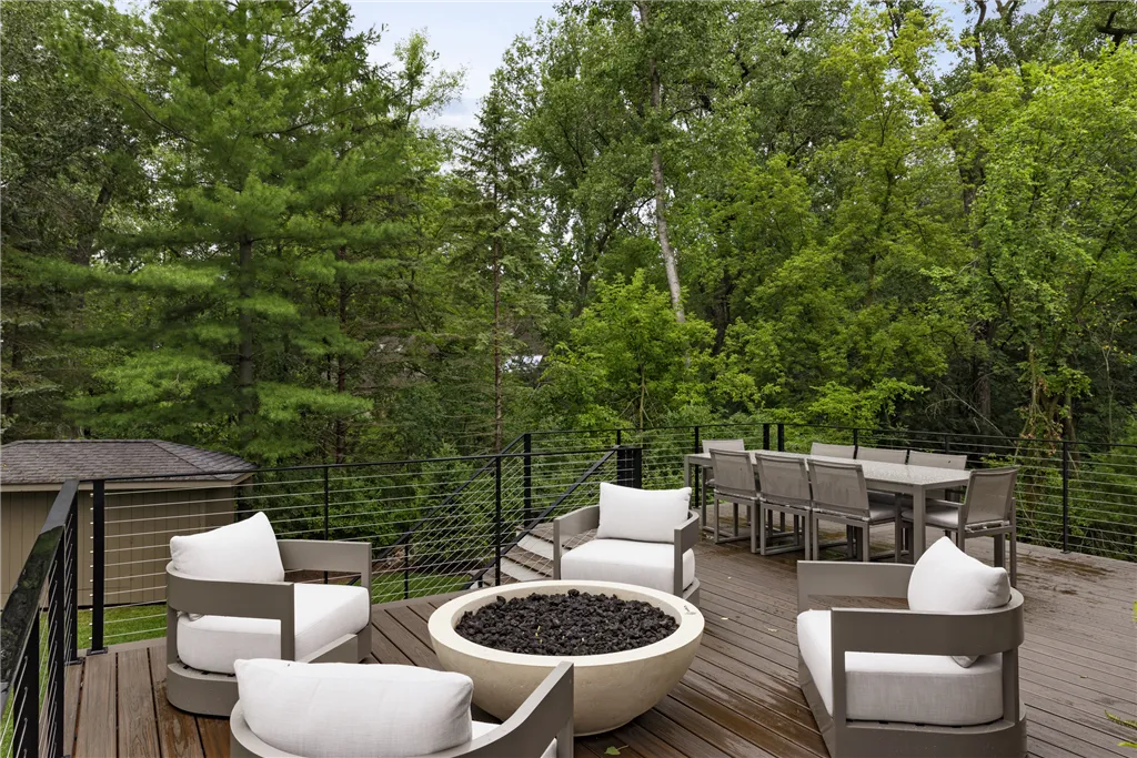 Luxury outdoor patio with wooden seating and nature backdrop.