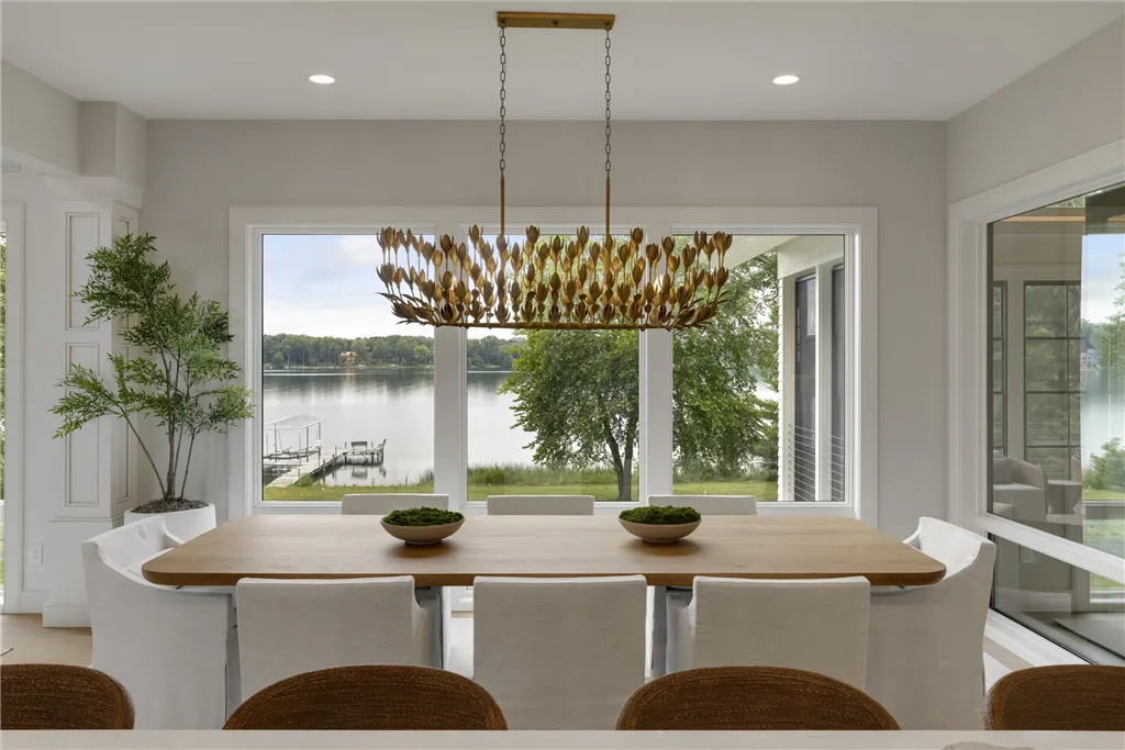 Luxury contemporary dining room with table, chairs, and flower arrangement by Hartman Homes.