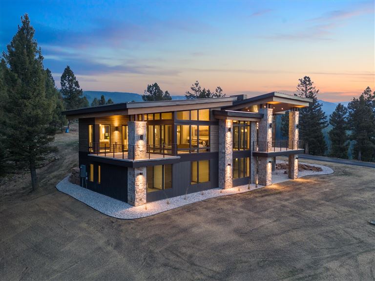 Wooden bungalow with porch at sunset surrounded by trees