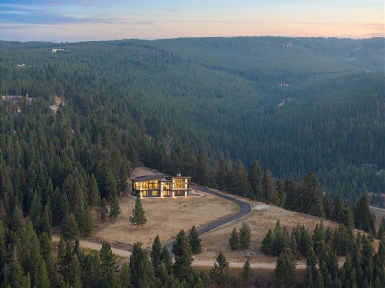 Scenic view of a mountain valley with a lake and evergreen forest.
