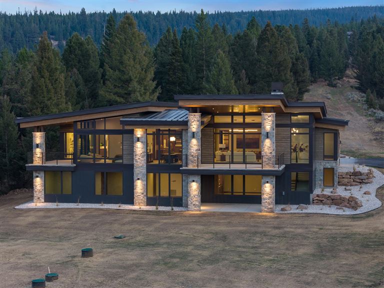 Rustic wooden cabin surrounded by trees in a serene landscape.