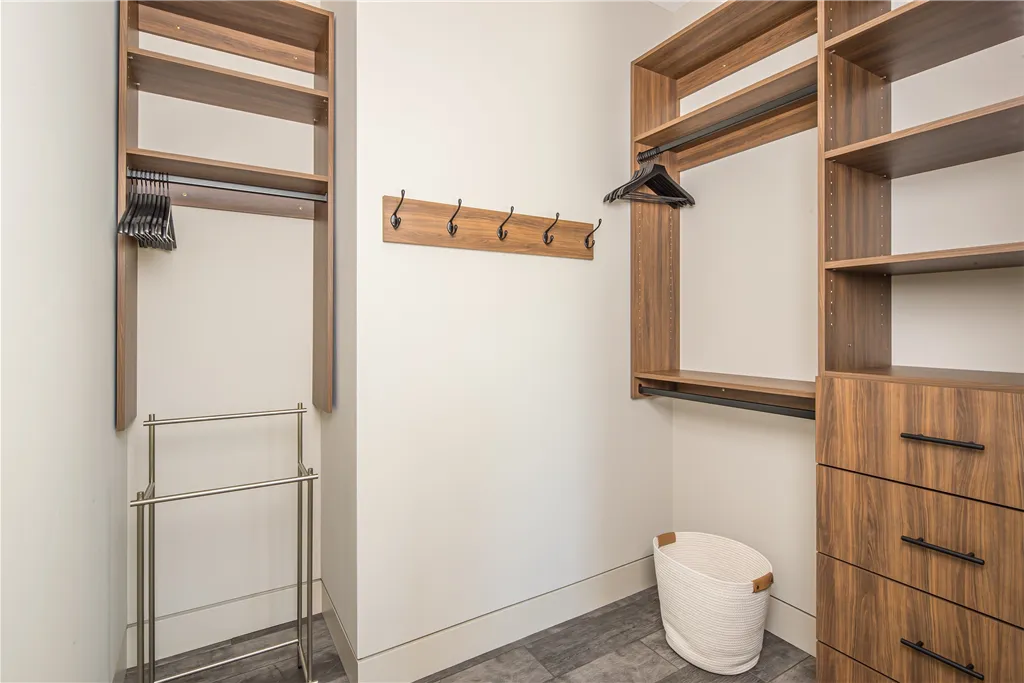 Contemporary built-in closet with wooden shelves and drawers in a minimalist design.