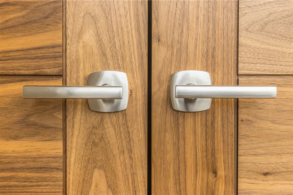 Closeup of a wooden door with a brass doorknob and lock.