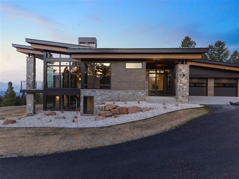 Suburban brick house with a garage and driveway in a quiet neighborhood.